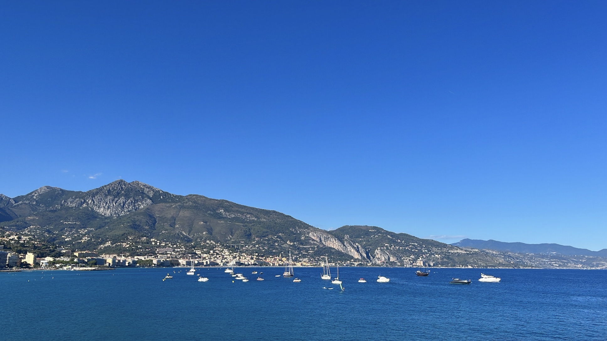 Din Tanovic — bay near Menton, sailboats anchored under the mountain at midday
