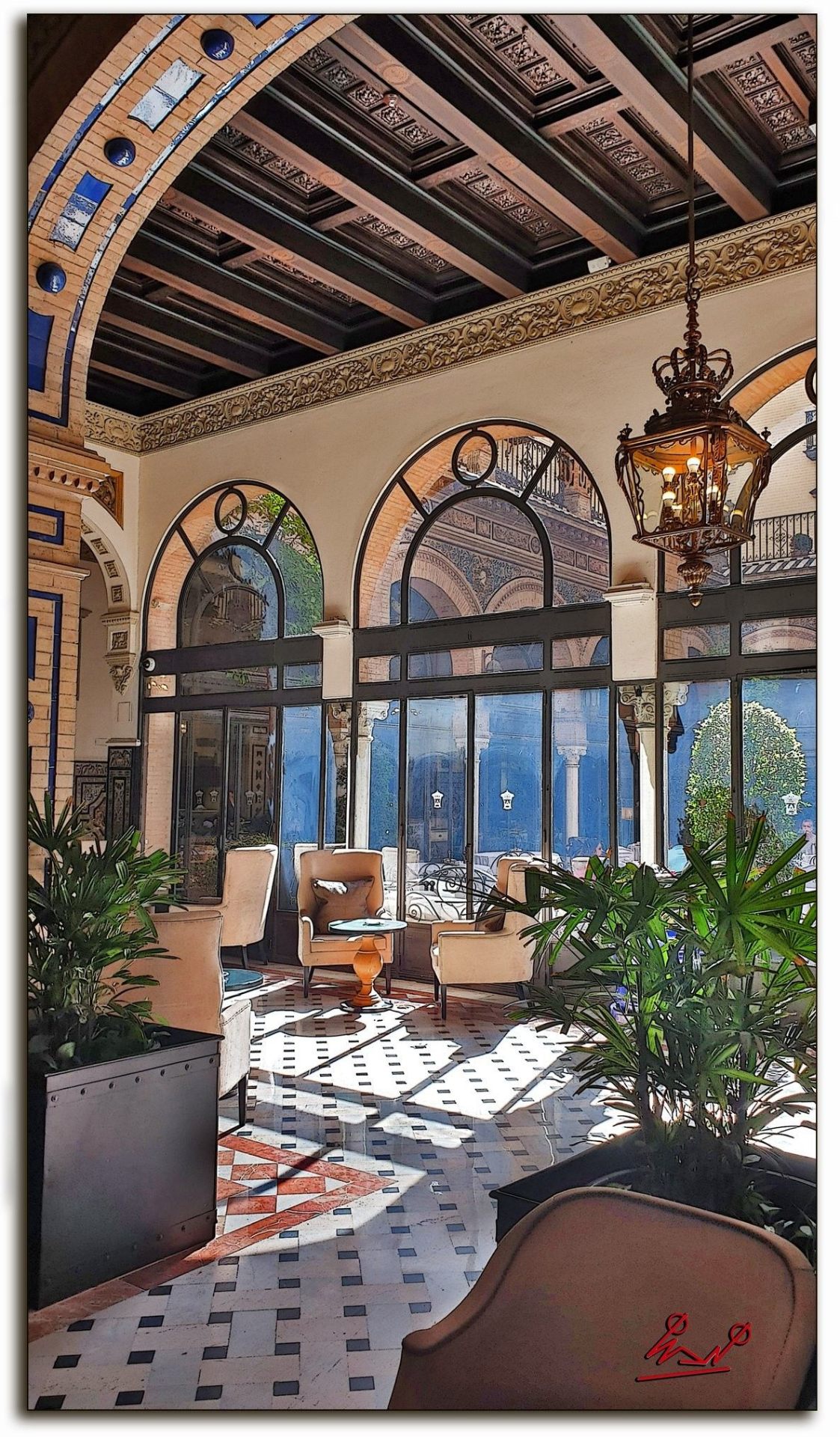 Sunlit interior lounge at Alfonso XIII with coffered wood ceiling, arched windows and patterned marble floor, Seville