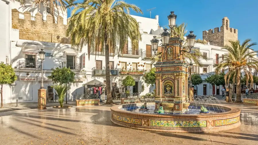 Plaza de España, Vejer de la Frontera — palms framing the ceramic fountain