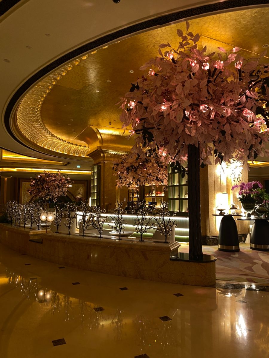 Emirates Palace Mandarin Oriental — golden fluted dome above the lobby lounge with pink blossom trees