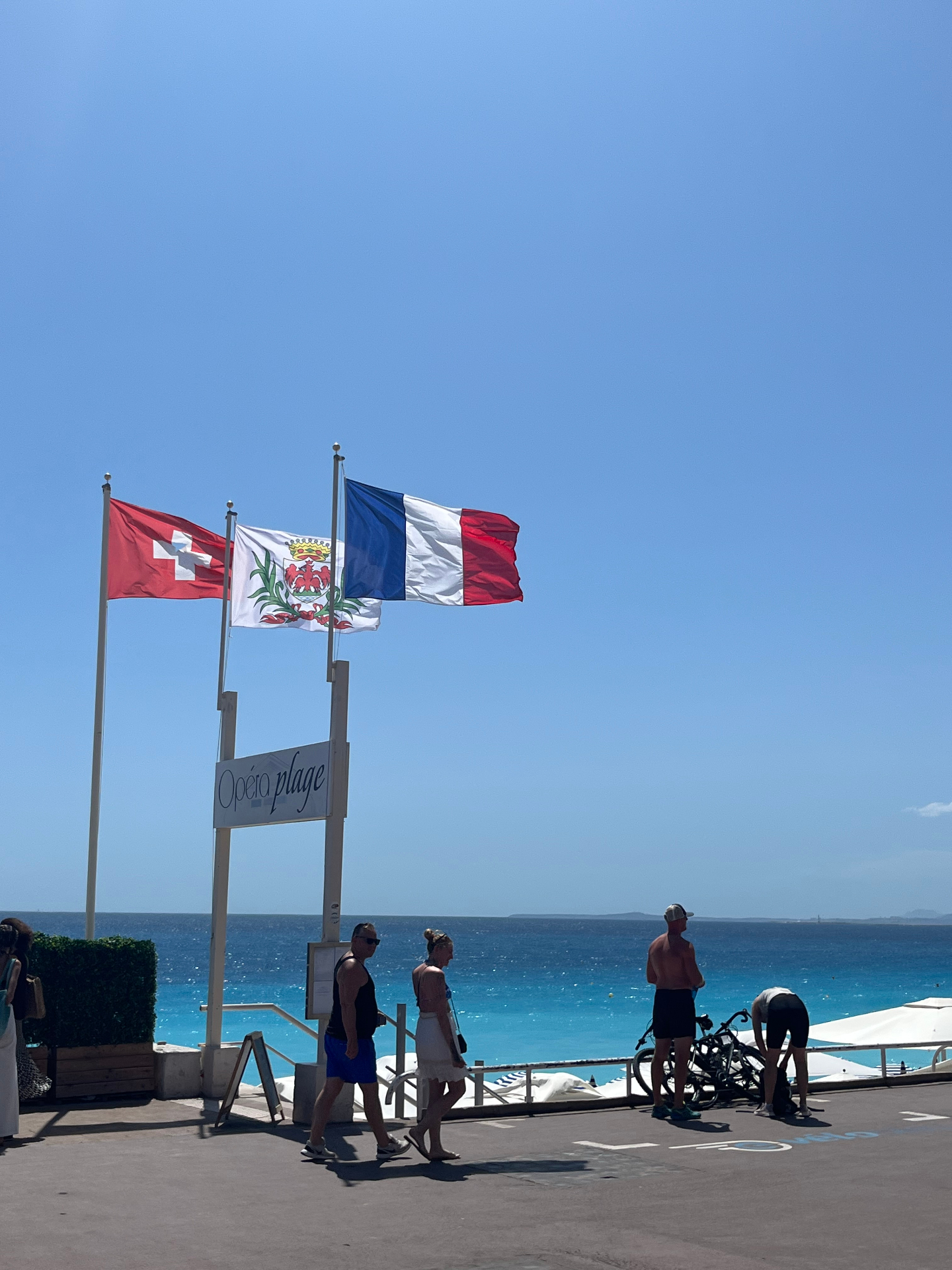 Din Tanovic — Opéra Plage flags above the Mediterranean in Nice, French and Swiss flags catching the wind