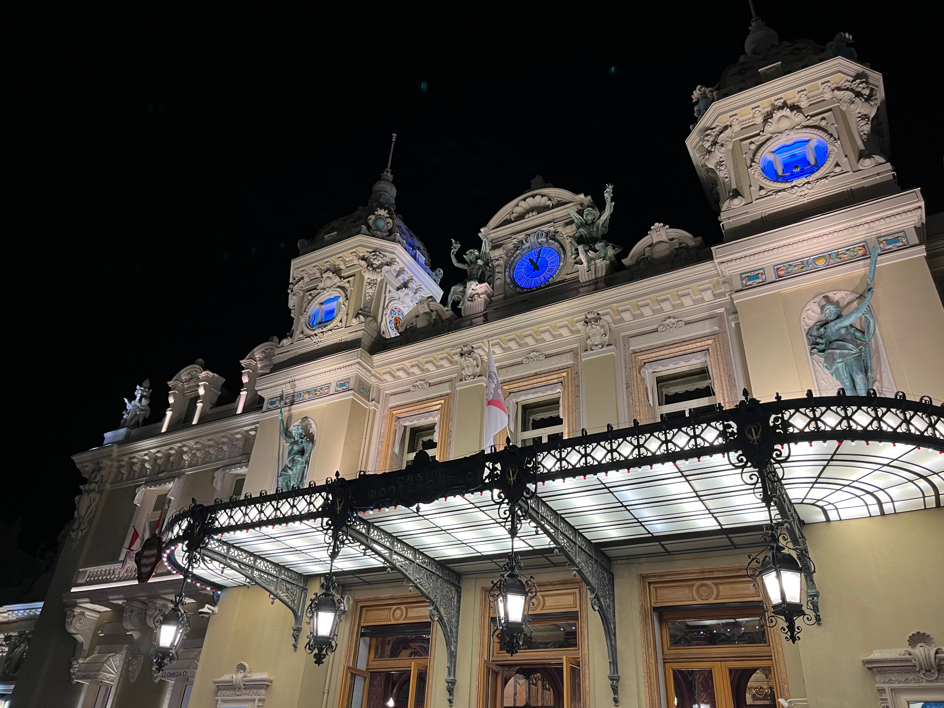 Casino de Monte-Carlo façade at night with lit marquee and clock towers