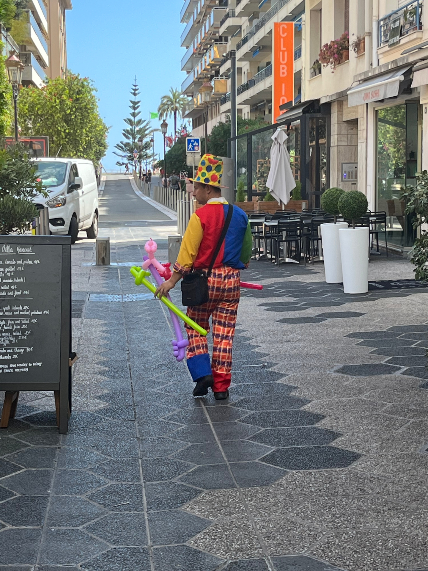 Din Tanovic — a balloon-seller in a Monaco side street, palms at the end of the road