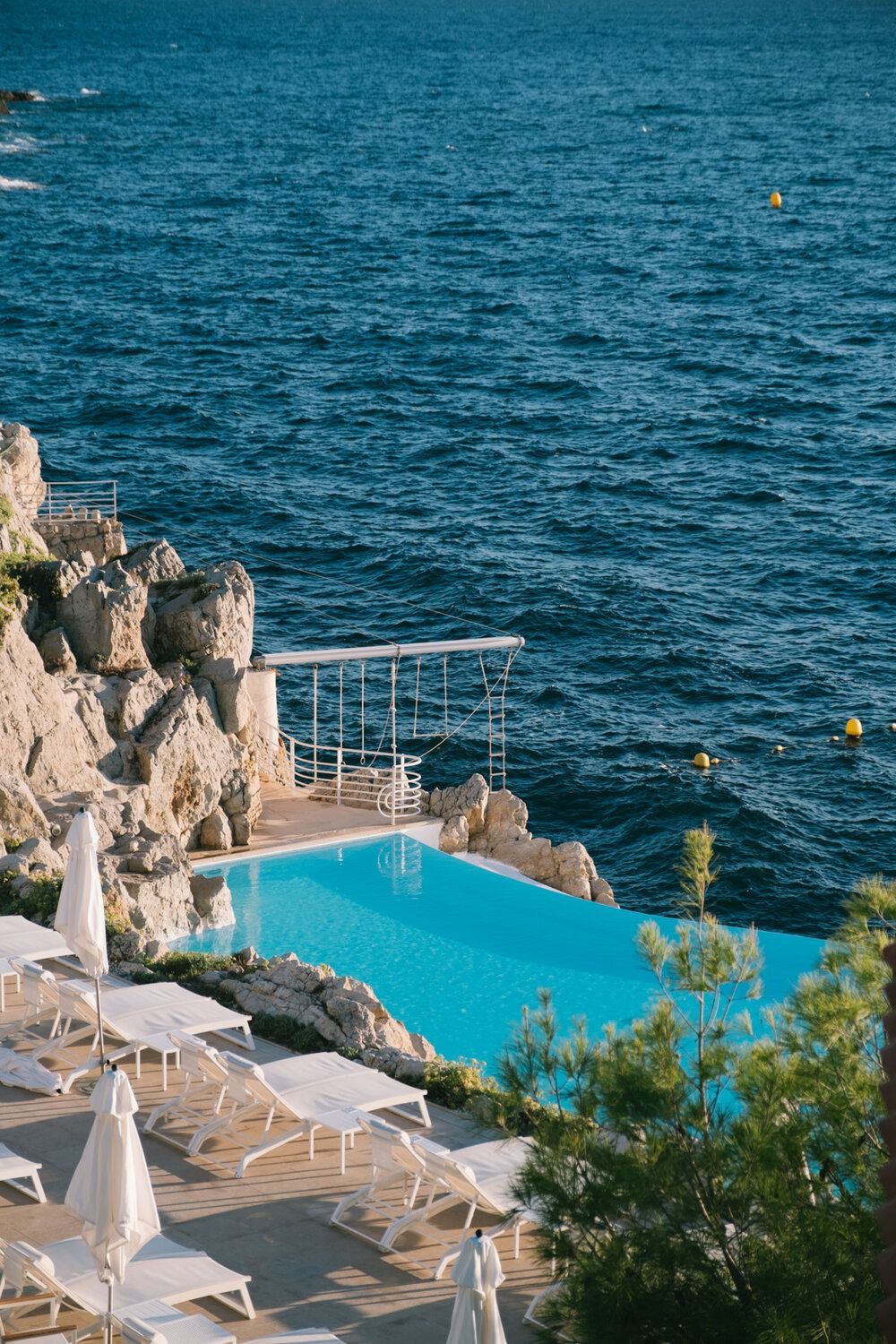 Hotel du Cap-Eden-Roc — cliffside seawater infinity pool over the Mediterranean at golden hour