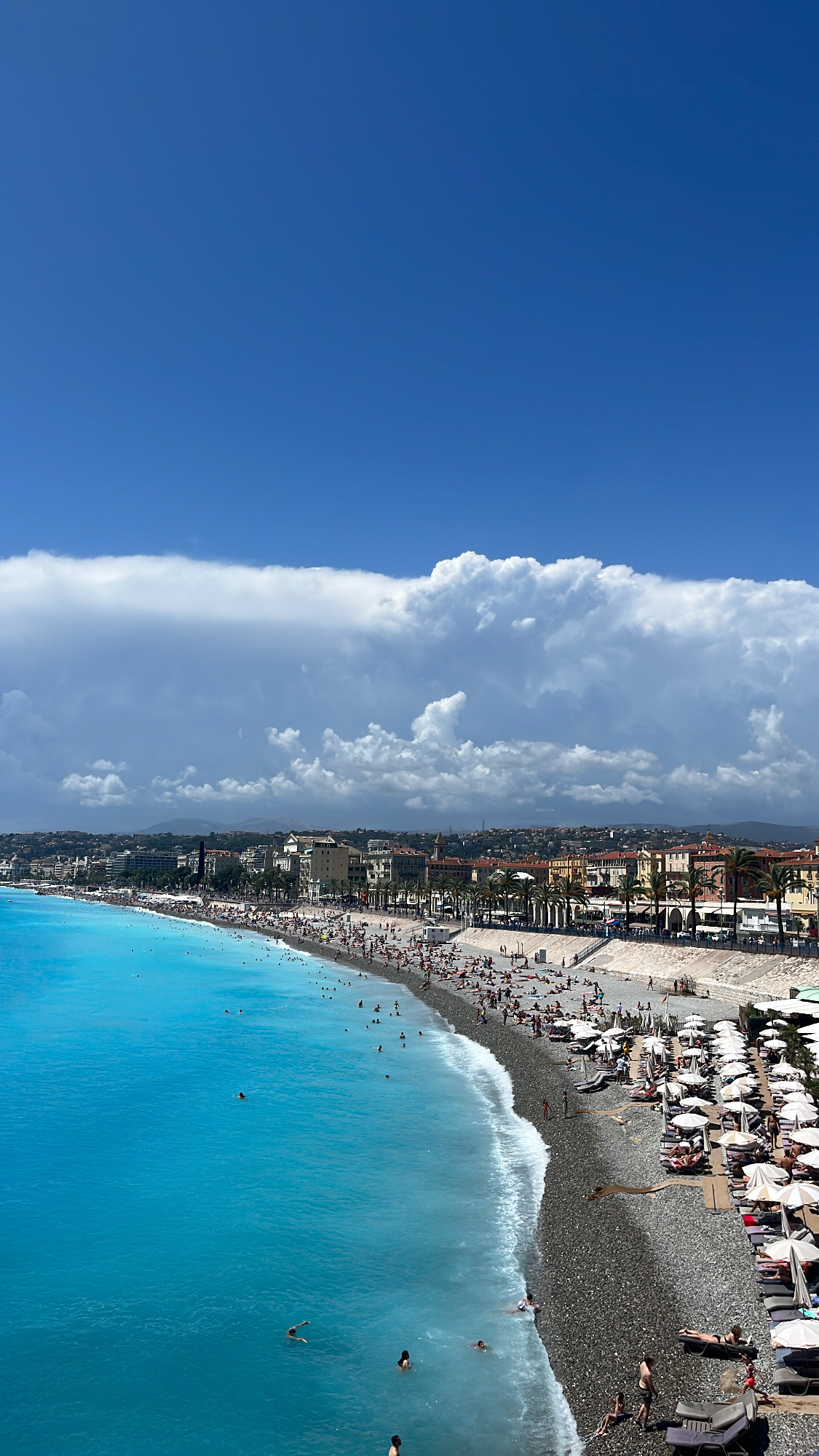Din Tanovic — Nice promenade and pebble beach from above, turquoise sea and stacked clouds